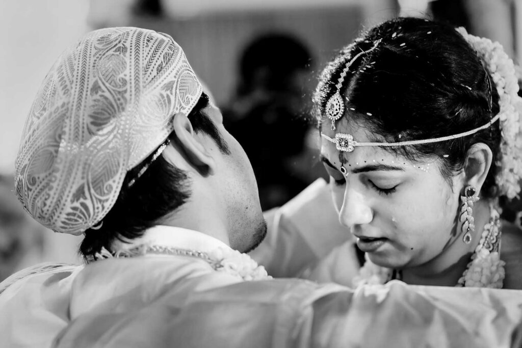 Black and white closeup of the bride and groom foreheads touching during a ritual