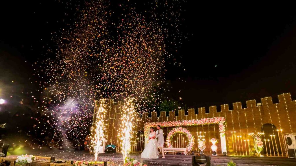 Confetti and fireworks light the night sky over the wedding stage
