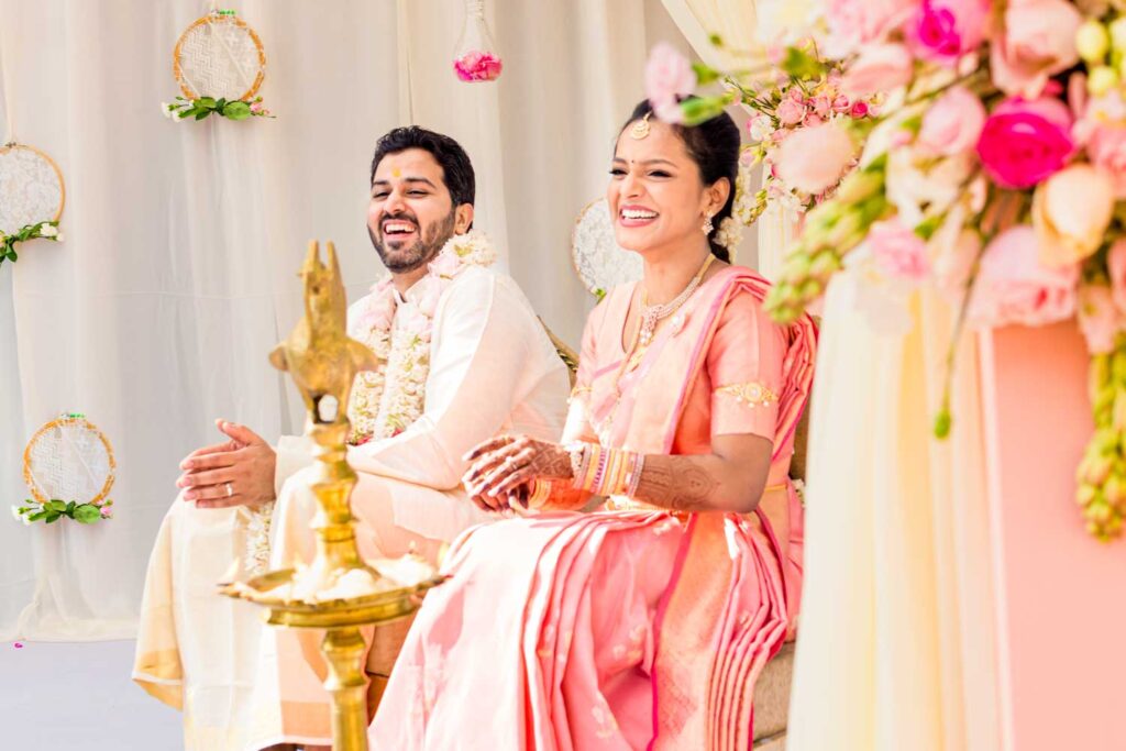Bride and groom smile together during a ceremony beside a floral arch