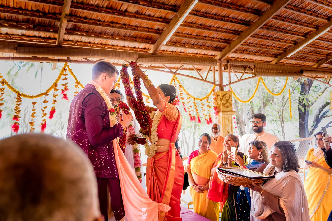 Sri Sri Ravi Shankar places a garland on Stefan while Medha stands beside him