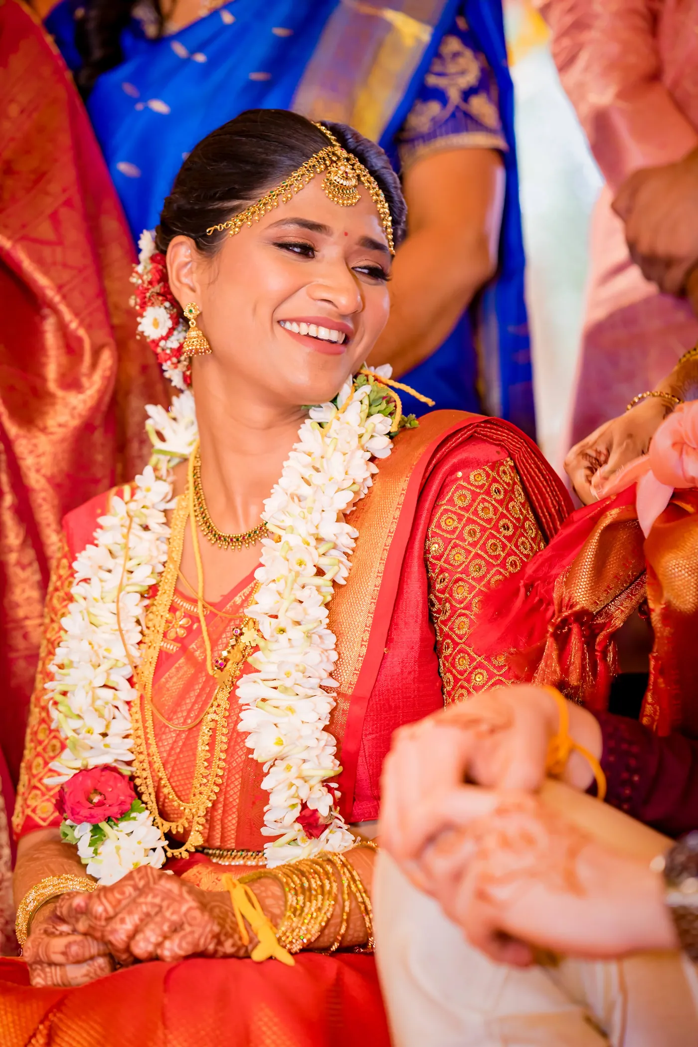 Medha laughs and glows in an orange sari and jasmine garlands during the ritual