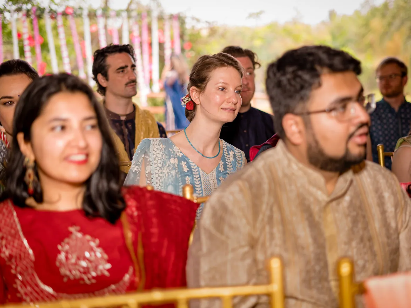 Guests from abroad and Indian guests sit together smiling at the ceremony