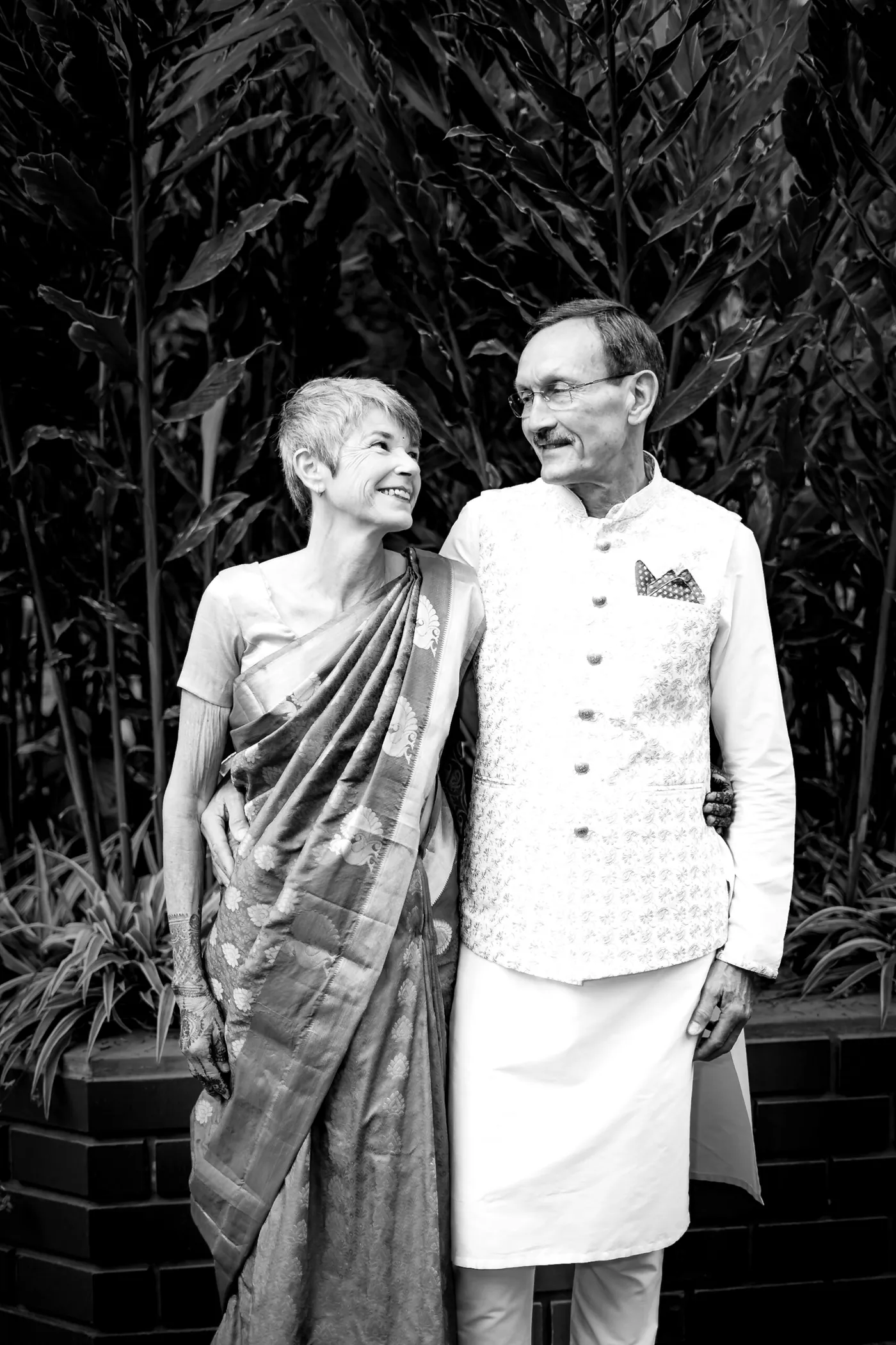 Black and white of Stefan's parents laughing together, she in a sari and he in a cream waistcoat