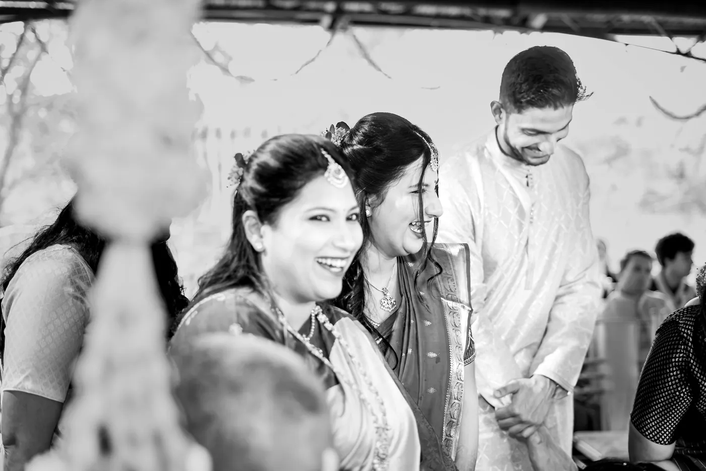 Black and white of a woman and a man smiling as they look toward the ceremony