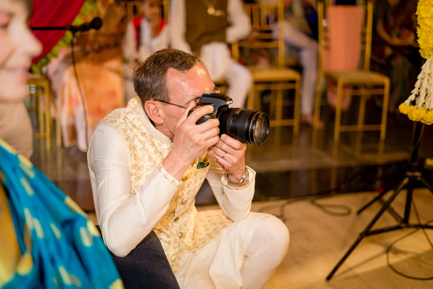 Stefan's father crouches with his own camera to photograph the ceremony