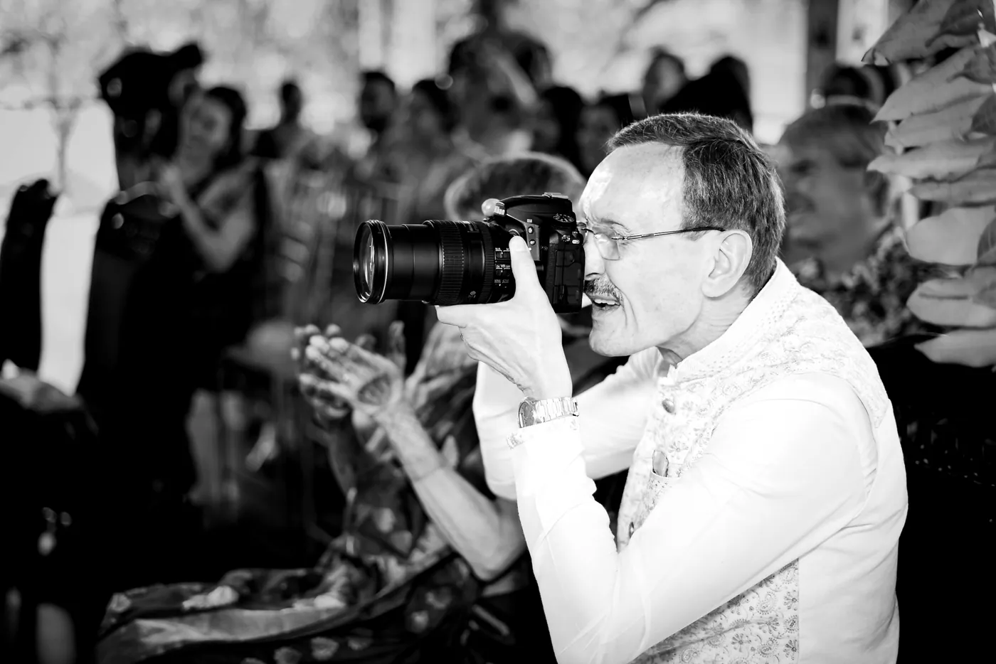 Black and white of Stefan's father lifting his camera toward the couple