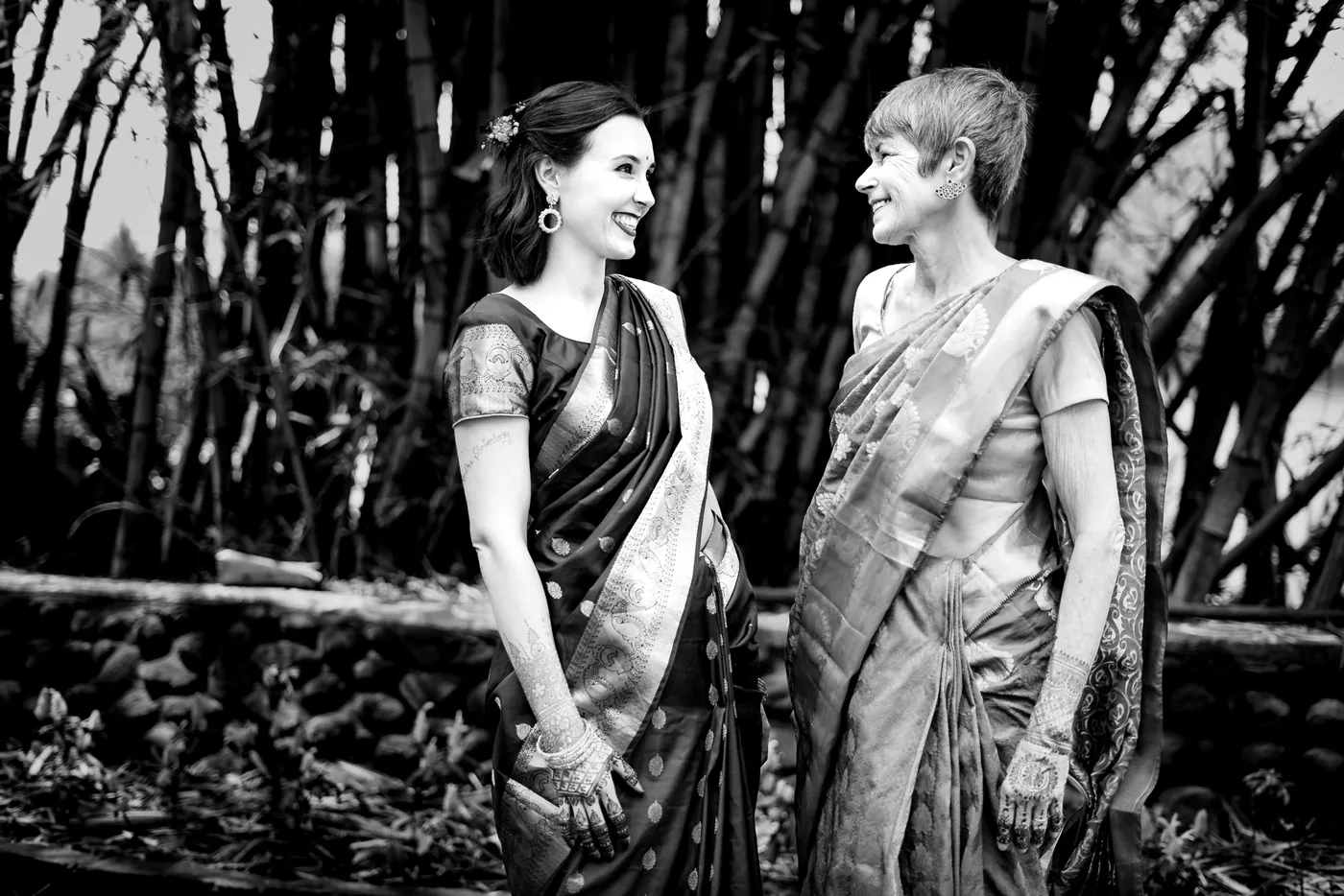 Black and white of Stefan's sister and mother laughing together among tall bamboo