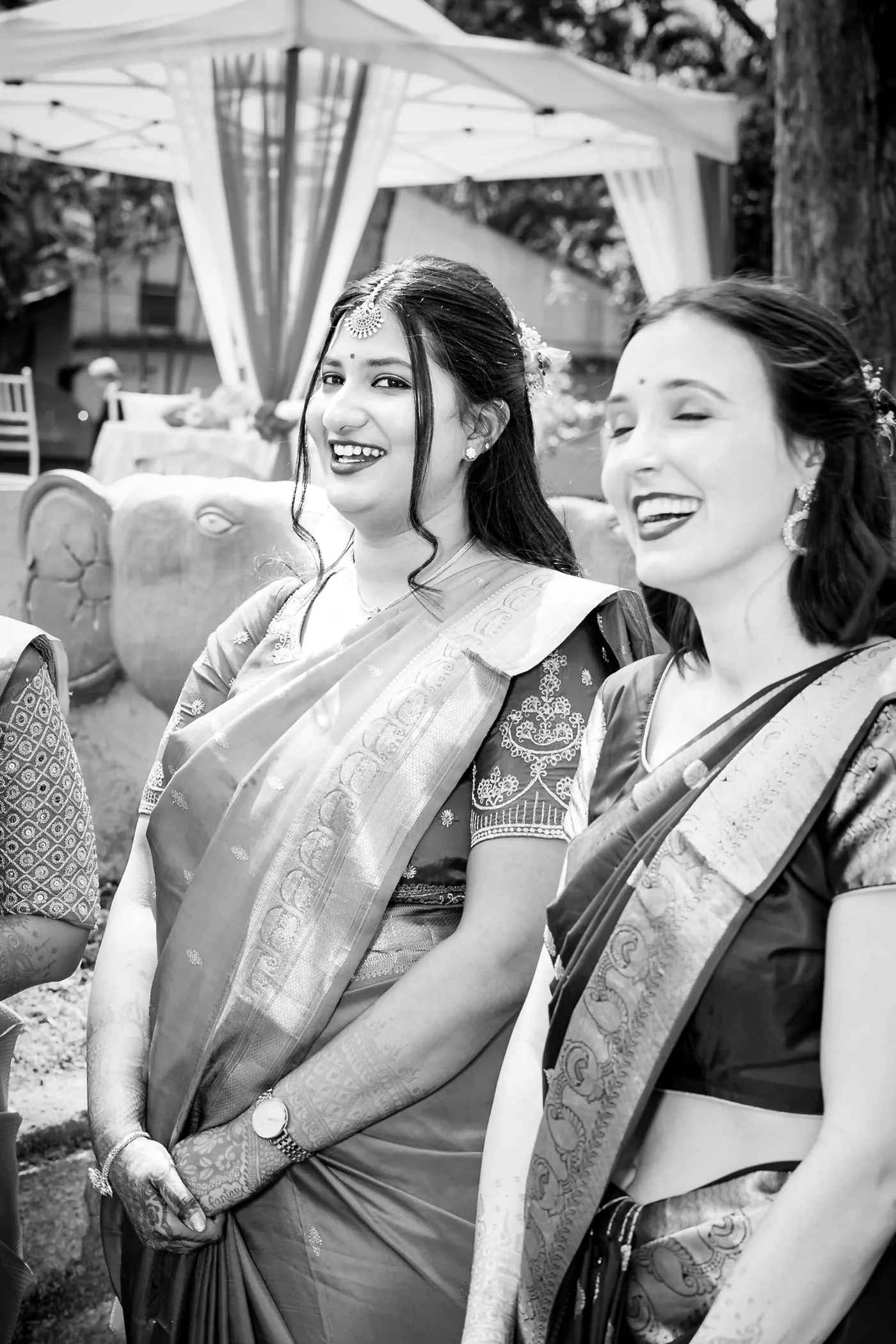 Black and white of two women in saris laughing together