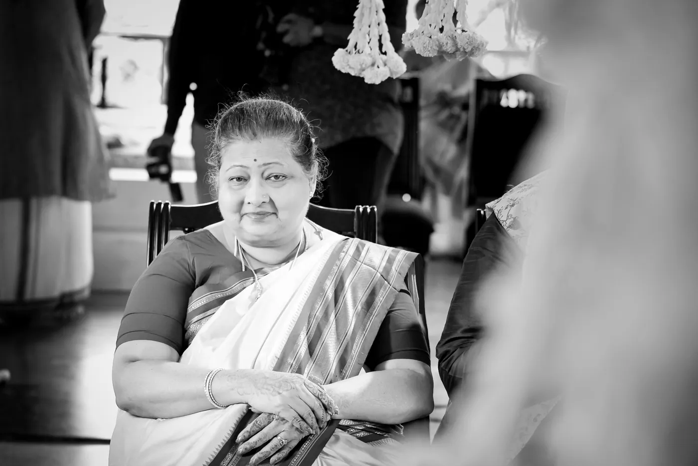Black and white of an older woman in a sari sitting with a gentle expression