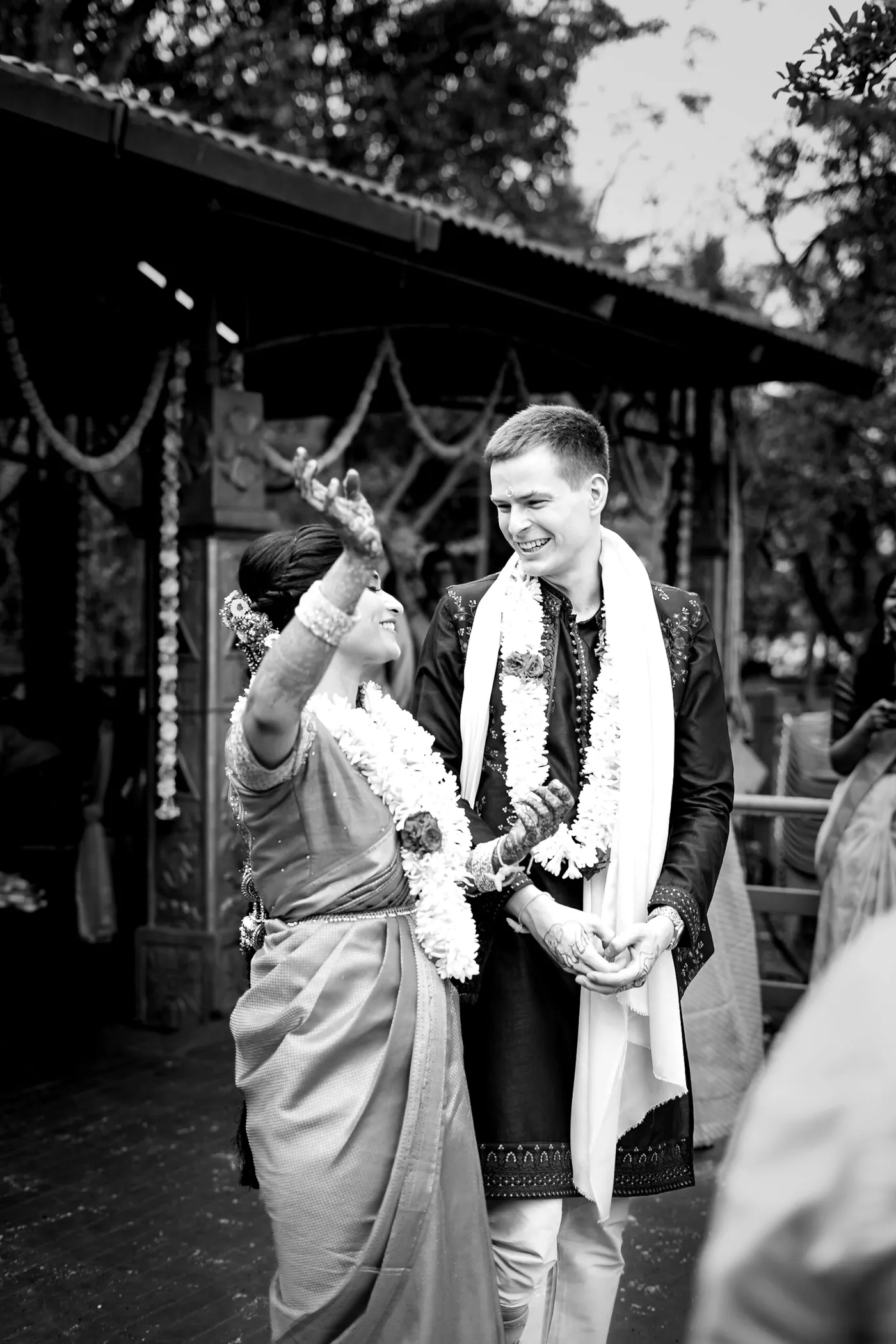 Black and white of Stefan in a white shawl beside a woman raising her arm on the deck