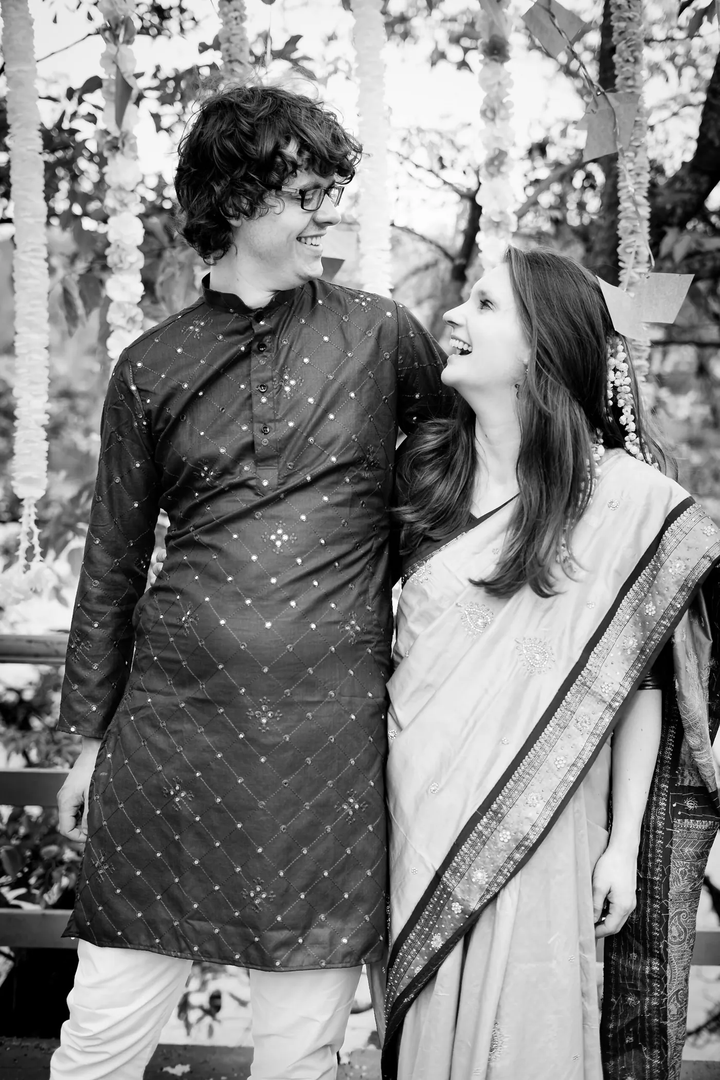 Black and white of a man and a woman laughing together in a garden