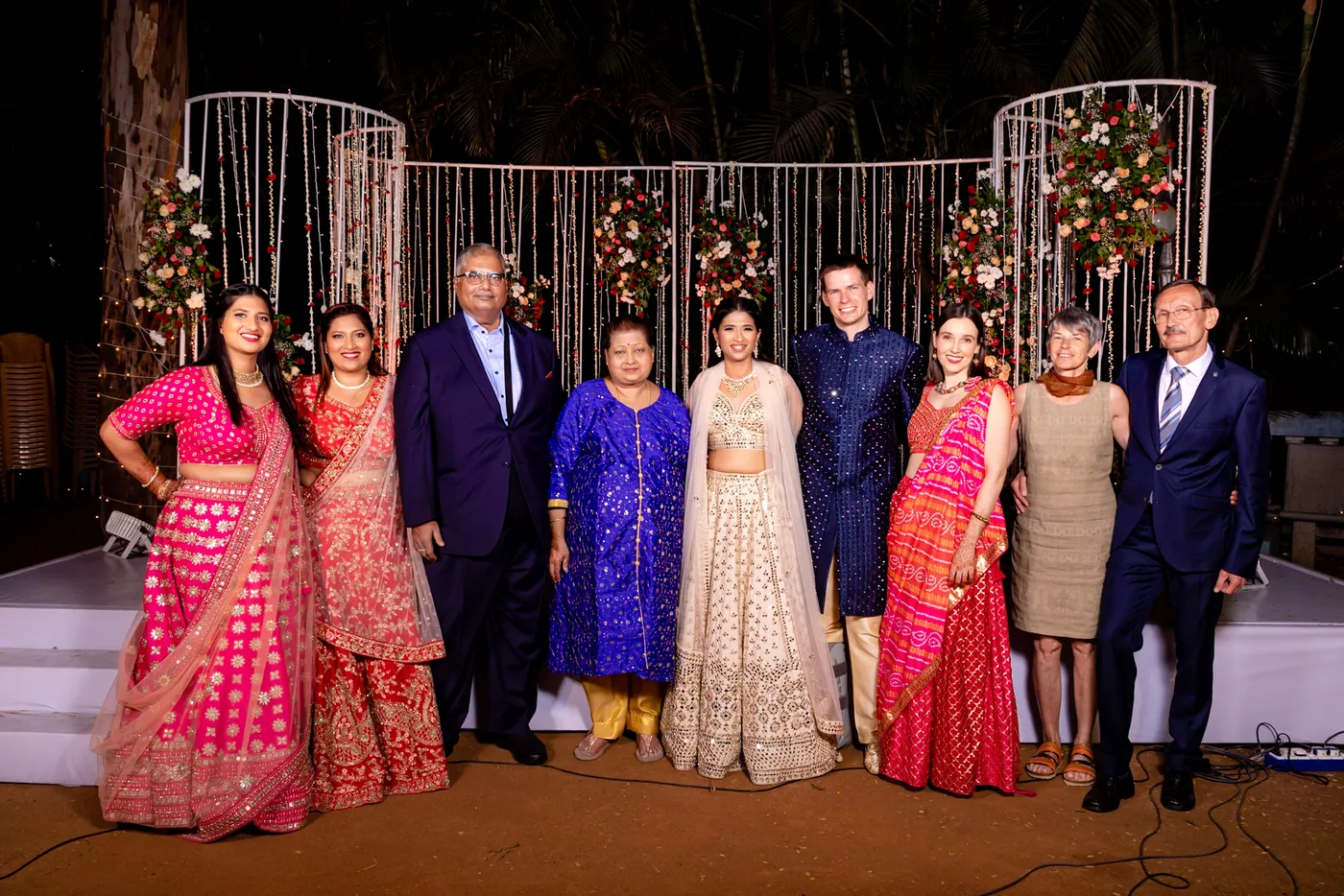 Both families line up on the stage: Medha's sisters and parents, Medha and Stefan, then Stefan's sister and parents