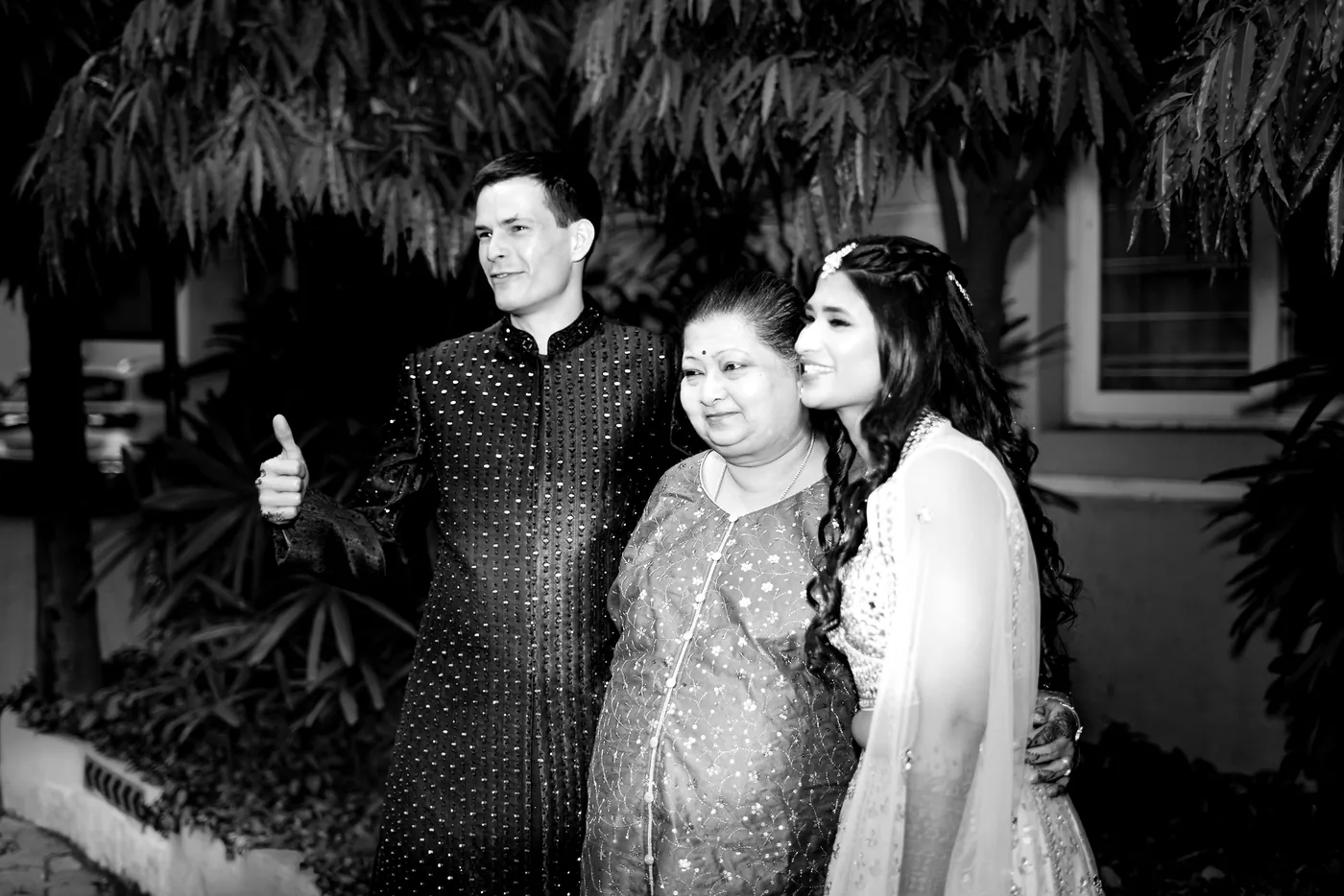 In black and white, Stefan gives a thumbs up beside a smiling older woman and Medha