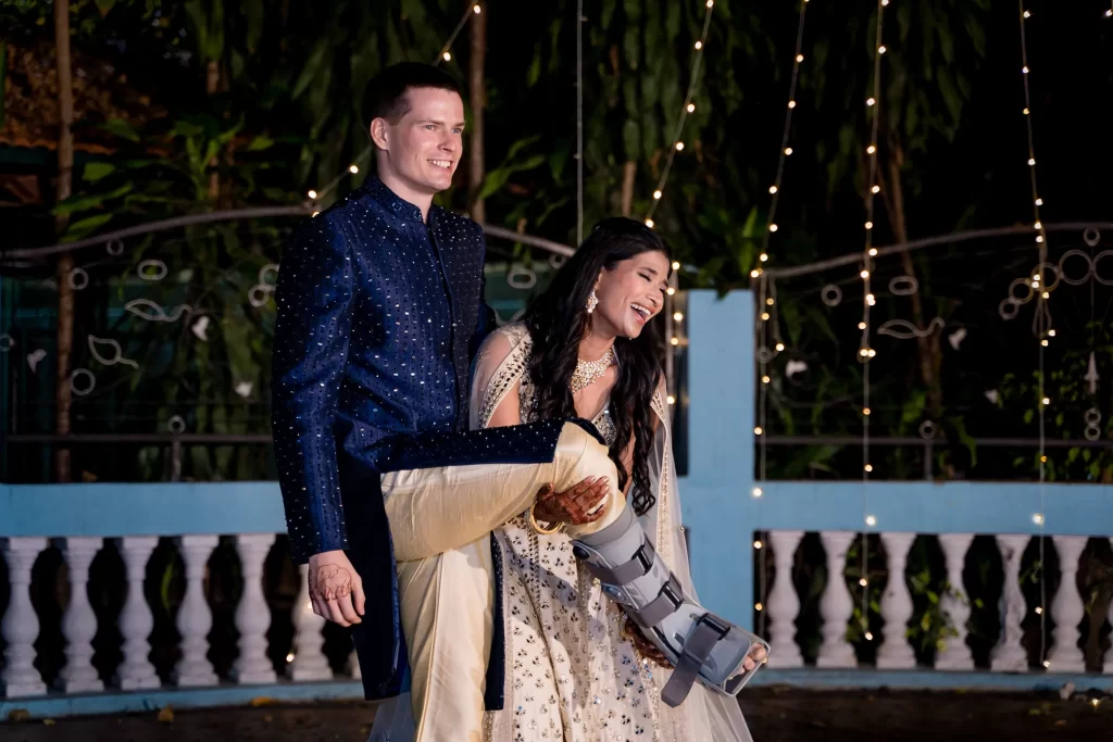 Medha laughs as she holds up Stefan's leg in its medical boot on the dance floor at The Bangalore Club