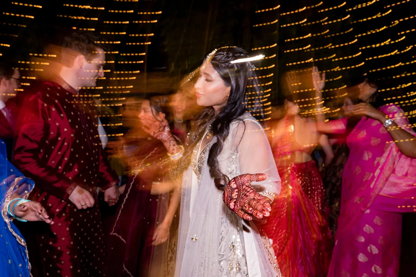 A long exposure turns Medha and the dancers into streaks of colour and light