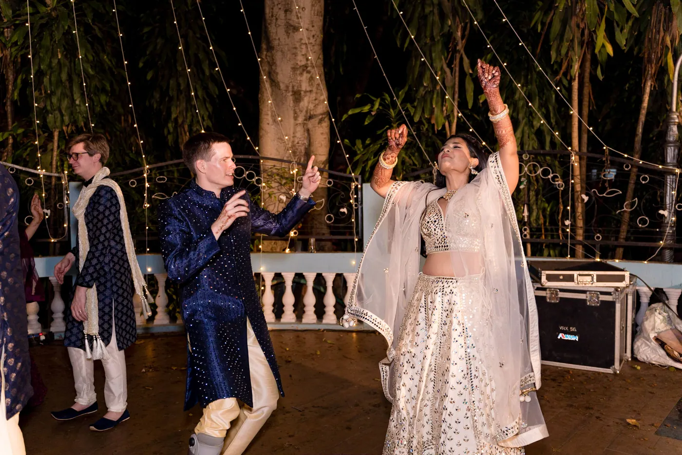 Stefan in his navy sherwani dances with Medha, who points an arm to the sky