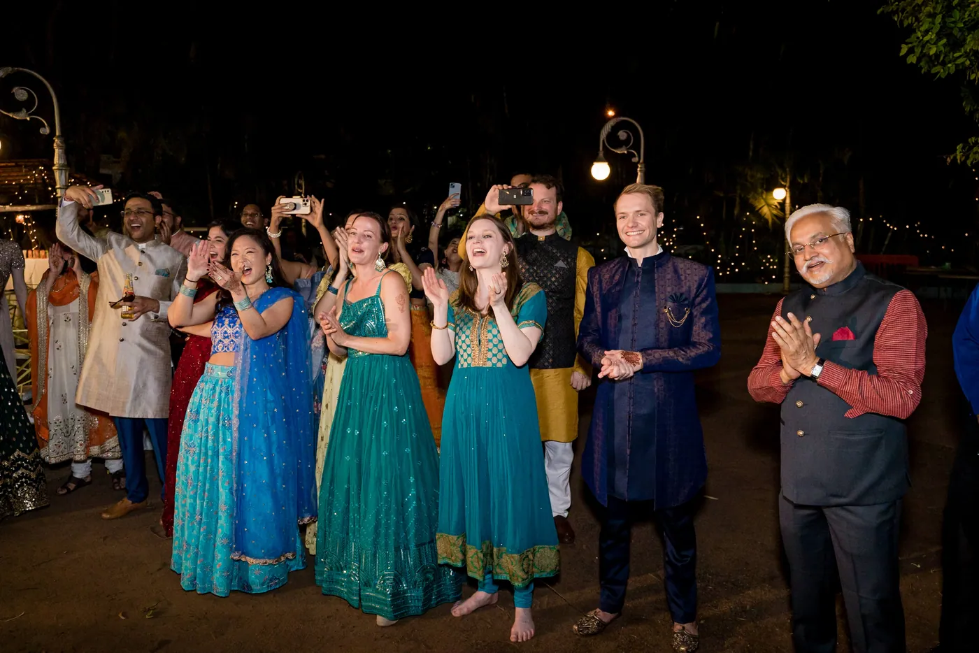 Guests in teal and blue stand at the edge of the floor as a man in a waistcoat dances