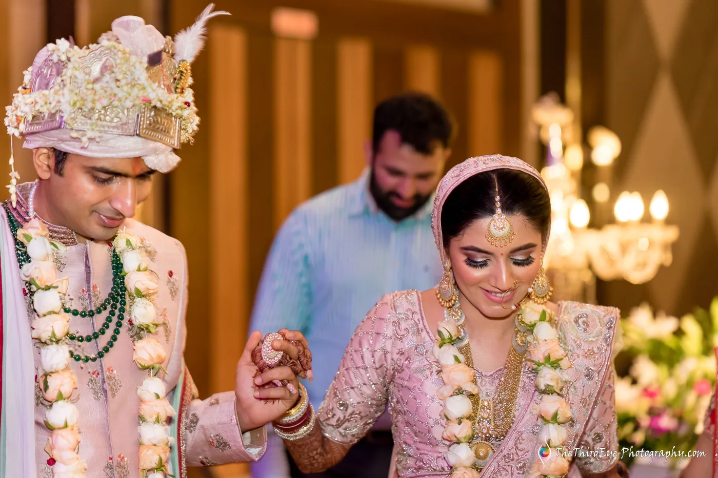 Ramit and Arushi walk hand in hand, she smiling down, a man in blue smiling behind them