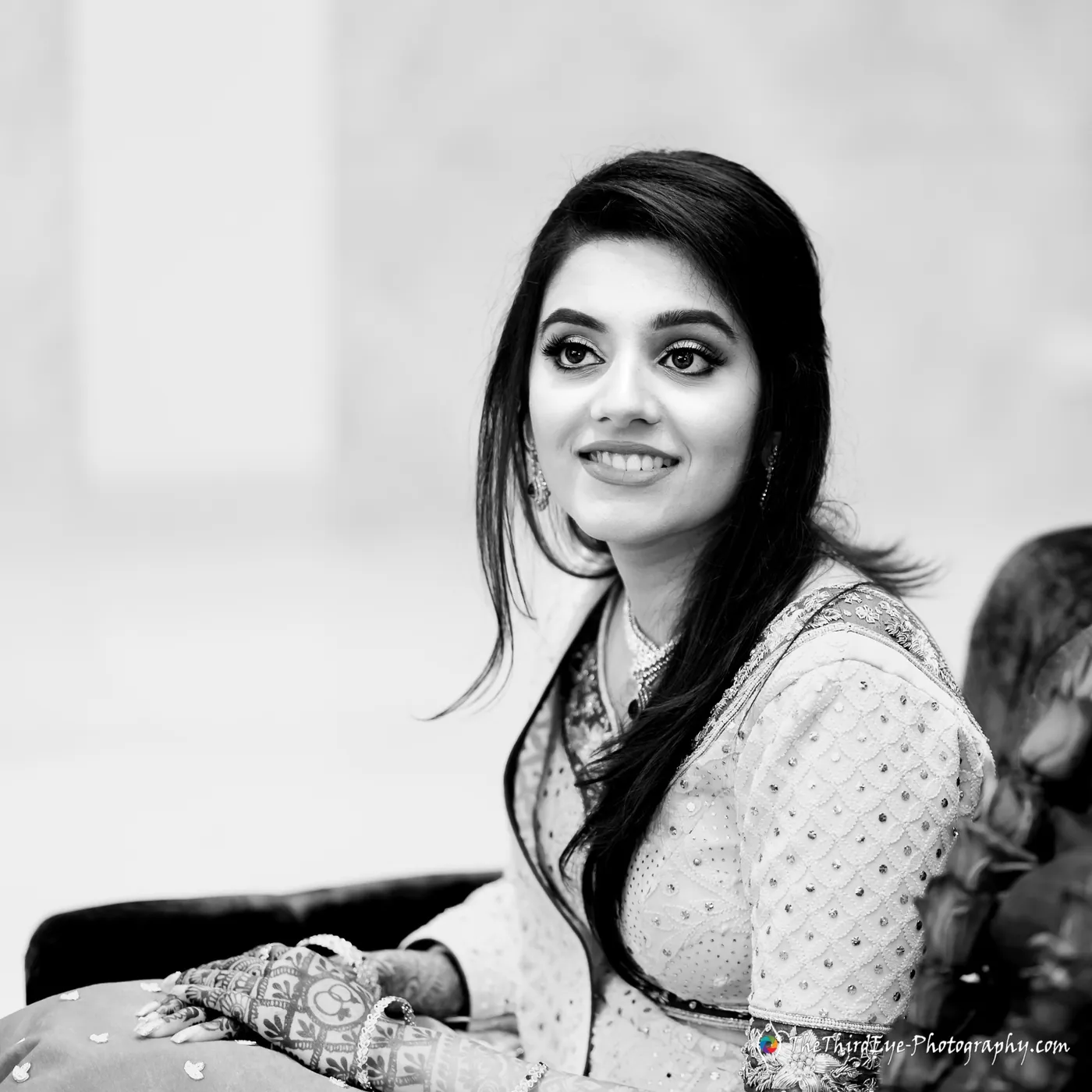 Black and white close portrait of the bride glancing off to the side, hair loose over one shoulder