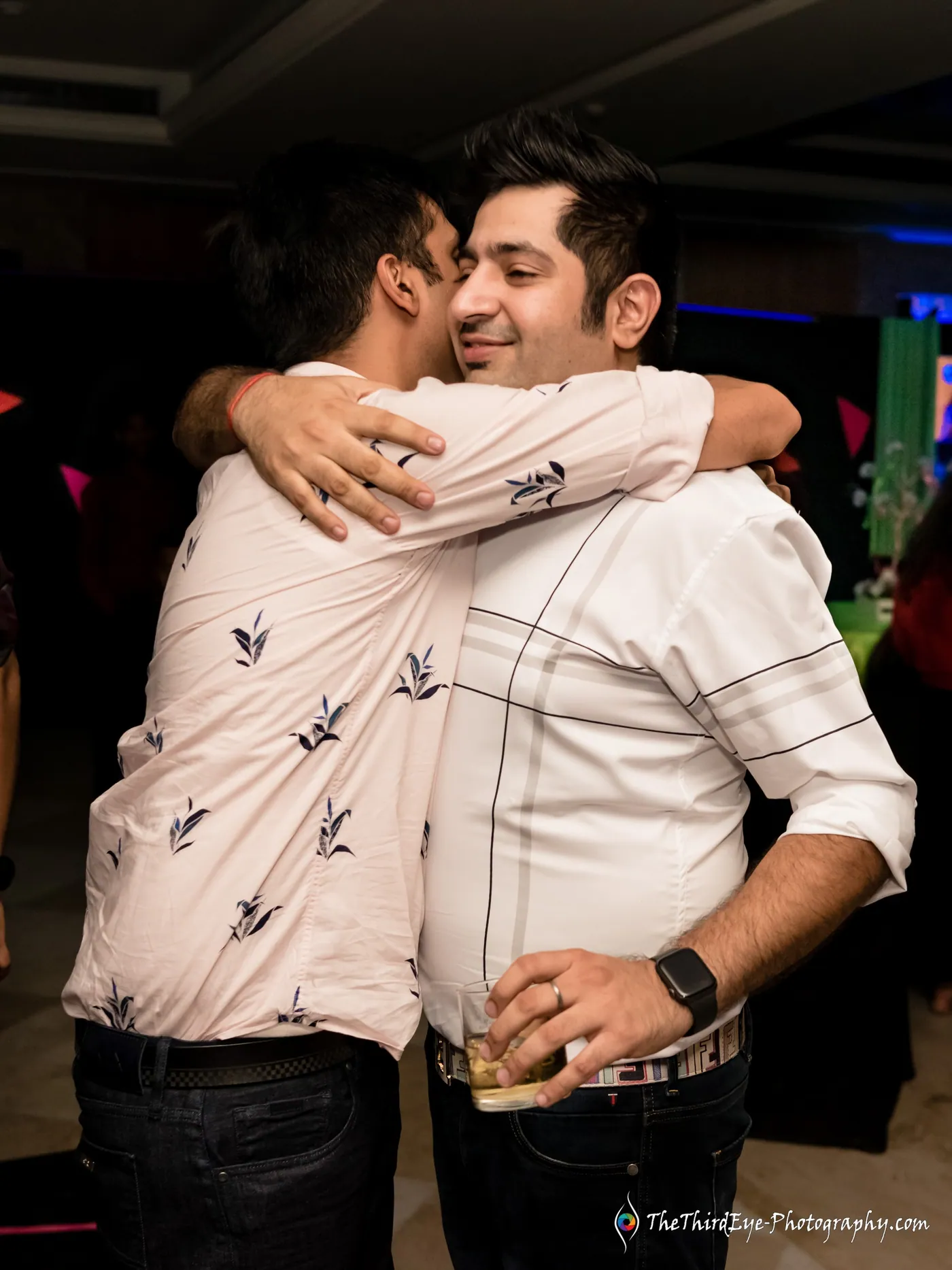 Two men in a tight bear hug, one burying his face in the other's shoulder