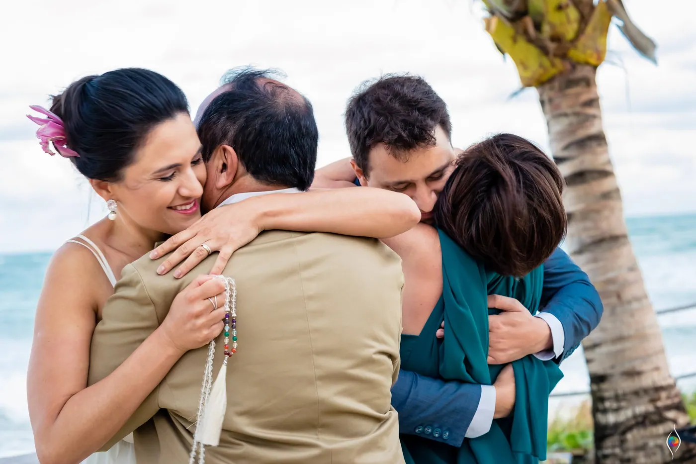 Evy wraps her arms around a man in a tan jacket while others crowd close around them