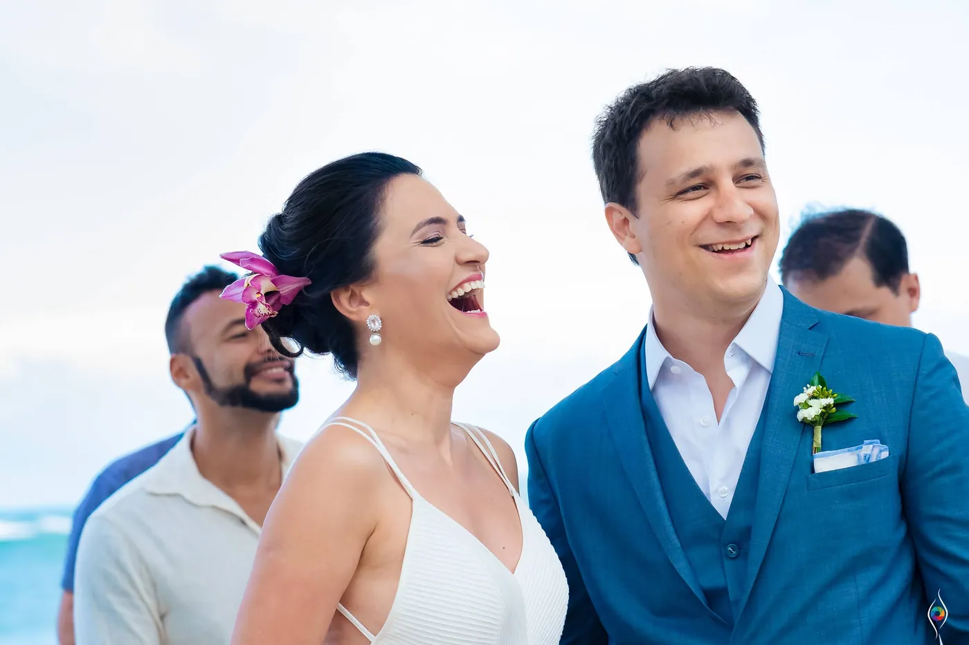 Evy laughs with her eyes closed as Thiago grins beside her, a friend smiling just behind