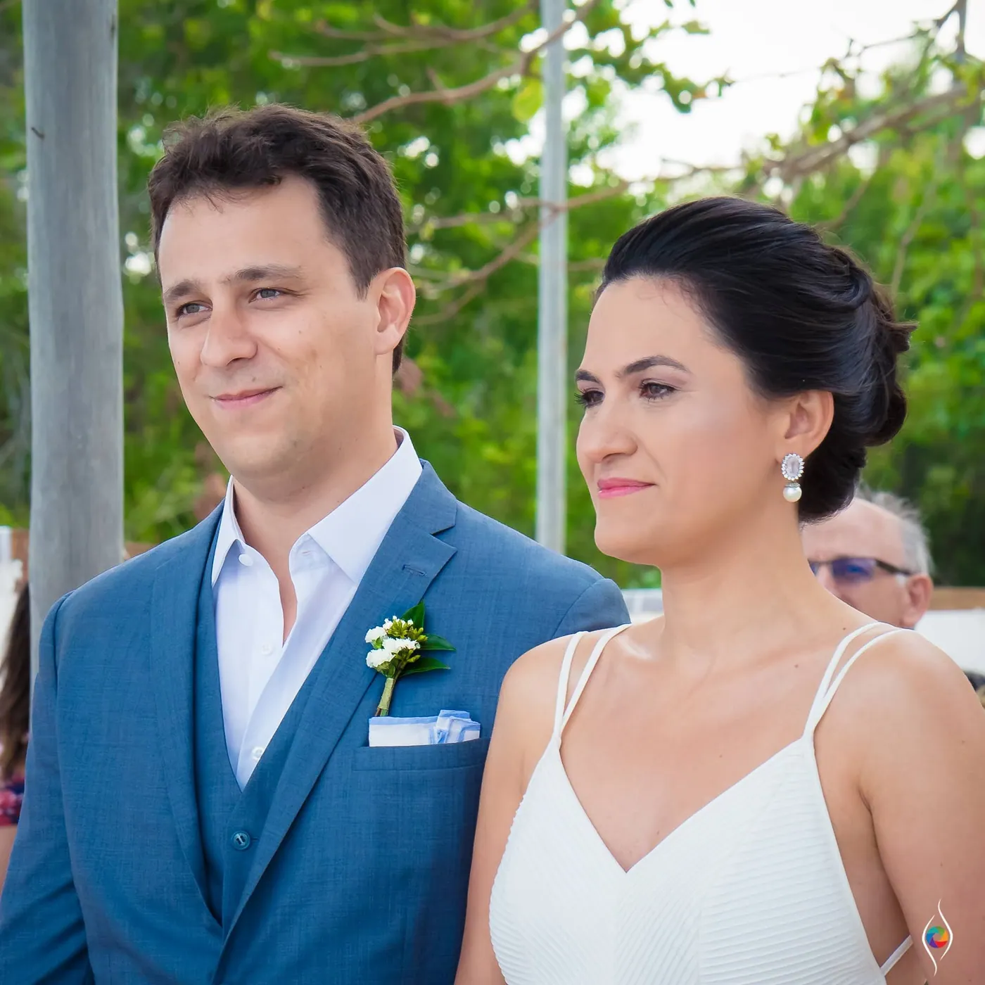 Thiago and Evy stand close and look ahead together, her drop earrings catching the light