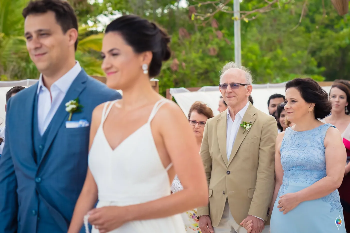 Thiago and Evy stand together as a man in a tan jacket and a woman in pale blue look on