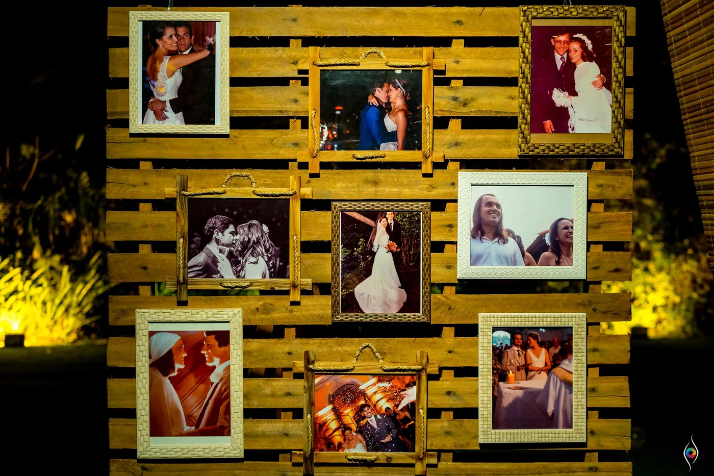 A wall of wooden pallets holds framed photographs of the couple and their families
