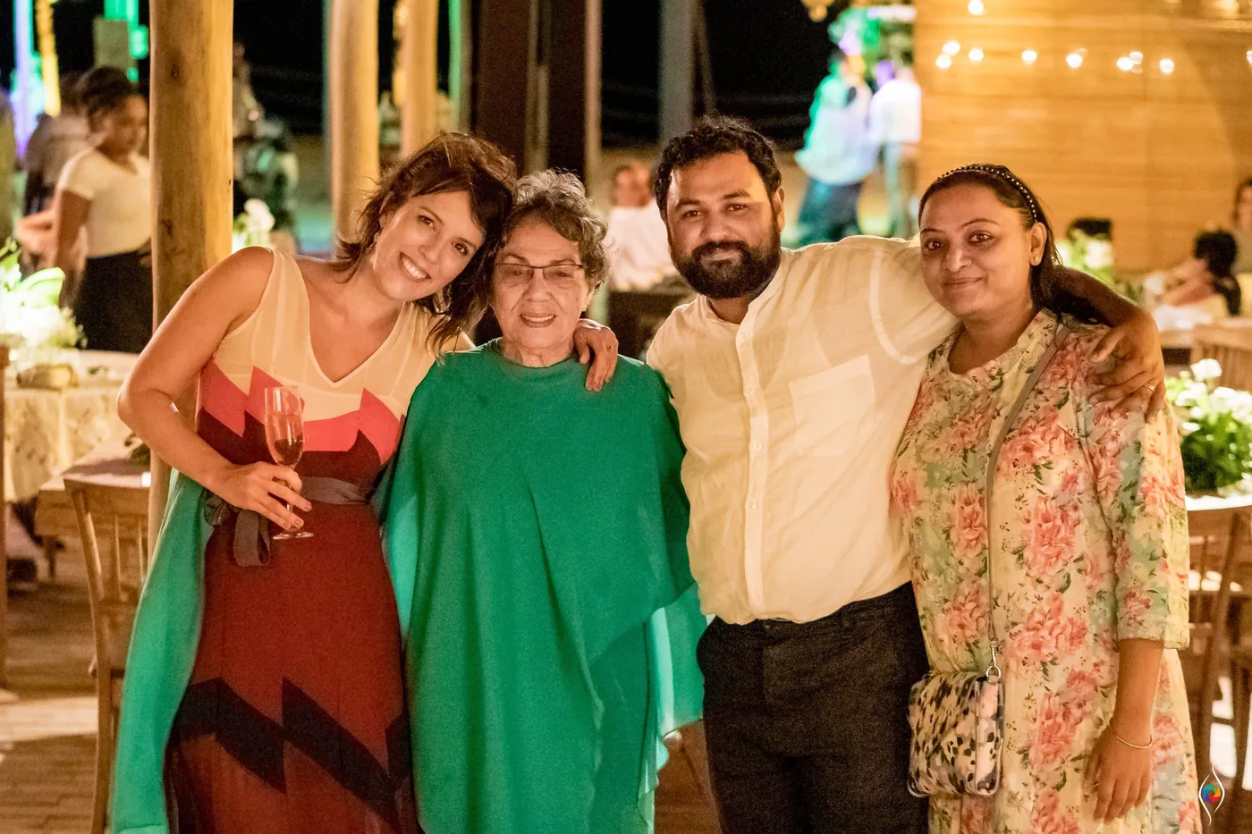 Evy's friends from India, a woman in florals and a bearded man in white, pose with an older woman in green
